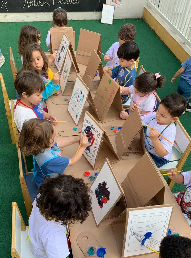 Crianças pintando em cavaletes no ateliê de artes da Lumirá